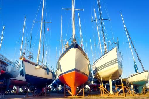 A view of the yachts at the dock. Sailing yachts parked in the marina. Maritime transportation. Dry dock. Yachts at anchorage in the off-season. Transportation composition. Yacht service.