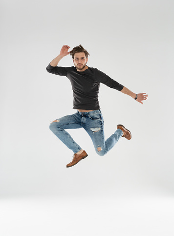 Full size of handsome guy jumping high rejoicing raising fists crazy competitive mood wear casual clothes isolated white background