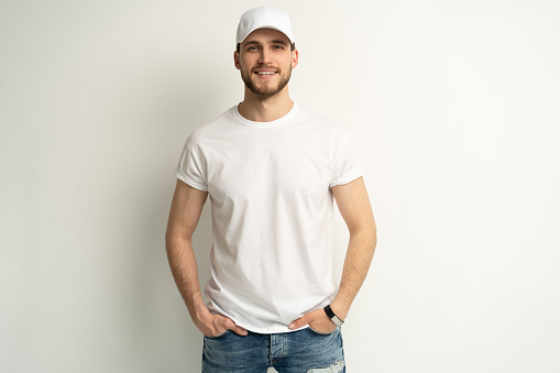 Handsome man wearing blank white cap and white t-shirt isolated on white background