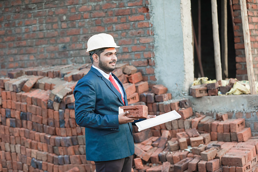 Portrait of civil engineer with safety uniform working at construction site outdoor, Construction worker checking and controlling project on building site, Architecture engineering on new project
