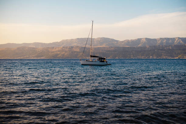 Sailboat floating in sea over mountain background in Supetar