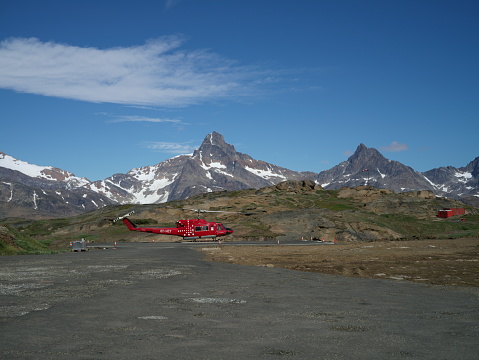 Air Greenland Bell 212 helicopter in Tasiilaq heliport  in Greenland with mountain scenery