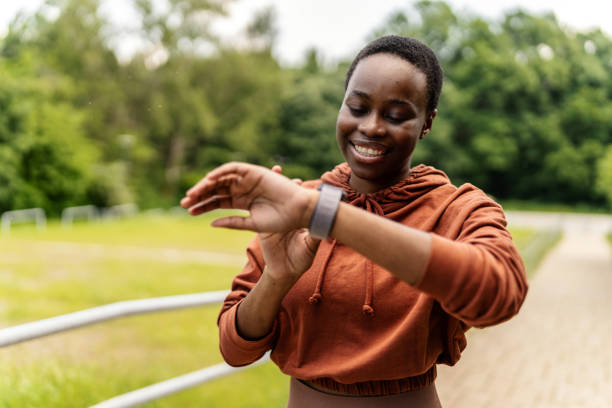 Shot of an athletic young woman checking her wristwatch. Slim cheerful female checking her pulse on smartwatch during training.