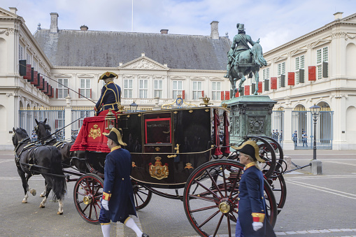 The Hague, The Netherlands - May 24, 2023; royal coachmen at a ceremony in front of Noordeinde Palace on Wednesday mornings when new ambassadors visit King Willem-Alexander and offer him their letter of credence. The audience includes a ceremony that can be followed from Noordeinde street. The ambassadors arrive by state coach, escorted by horsemen from the Royal Netherlands Mounted Police.