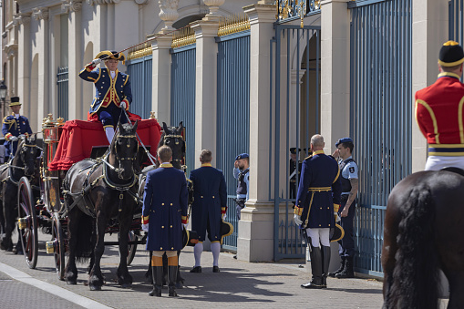 The Hague, The Netherlands - May 24, 2023; royal coachmen at a ceremony in front of Noordeinde Palace on Wednesday mornings when new ambassadors visit King Willem-Alexander and offer him their letter of credence. The audience includes a ceremony that can be followed from Noordeinde street. The ambassadors arrive by state coach, escorted by horsemen from the Royal Netherlands Mounted Police.
