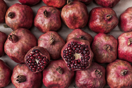 A close-up view of a basket of fresh and healthy Pomegranates (Punica granatum), a berry fruit native to south-western Asia, widespread in the Caucasus region and in Armenia, Afghanistan, Iran, Turkey, Pakistan and Malaysia and cultivated in the countries of the Mediterranean area. The traditional Mediterranean diet consists of natural, healthy and fresh products, including fruits, vegetables and grains. Image in high definition format.