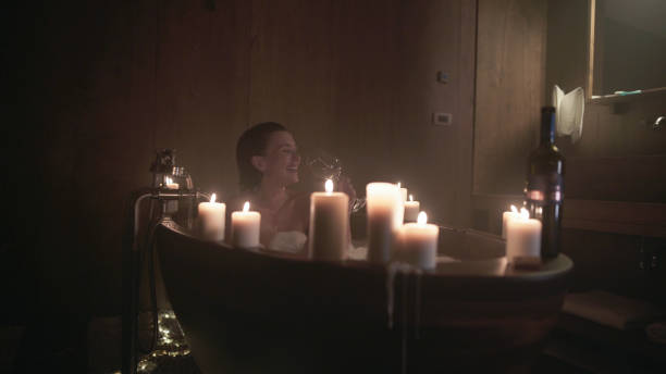 istock Beautiful woman relaxes in bath with candles 1804090406
