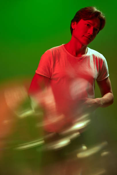 istock One handsome young guy, man standing with pensive face and looking up over green background in neon light. 1804096775