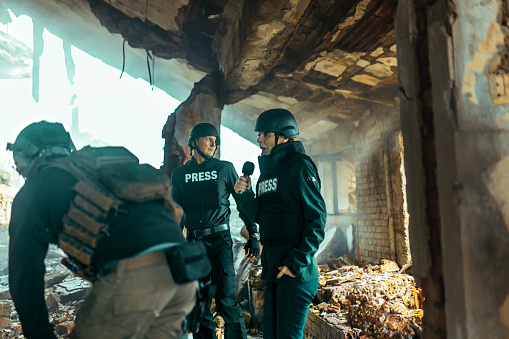 journalists in a war zone film soldiers and give an interview