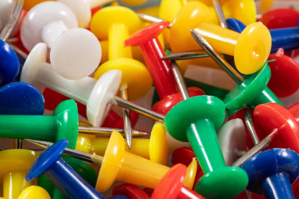 Group of multi-colored pushpins in tight close-up.