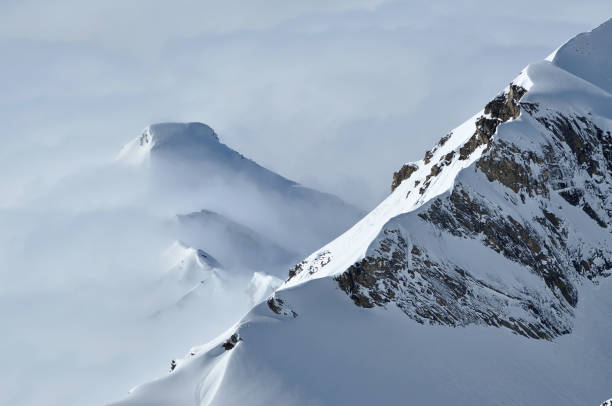 istock Snow covered high mountains, fog and clouds raising from above 1804123978