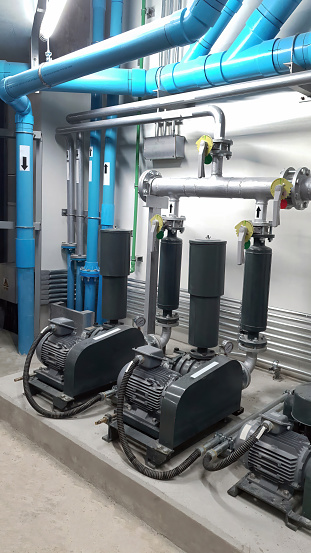 Set of equalization pump installed in the basement with vertical and horizontal pipeline flow for building engineering system, construction, plumbing