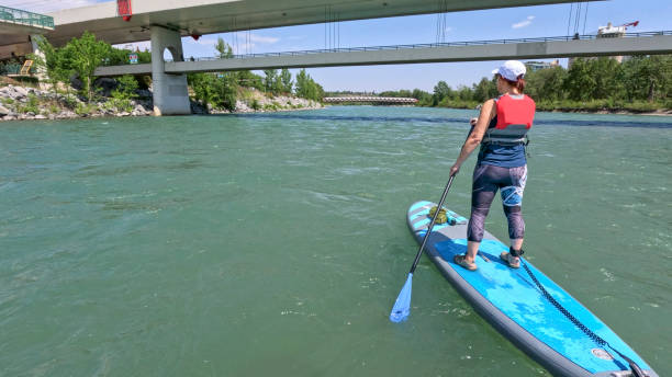 istock Woman paddle boarding (SUP) towards bridges 1804128128