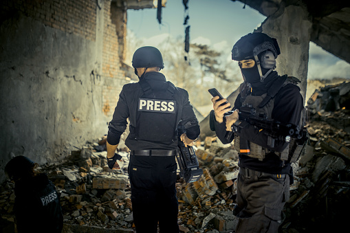 journalists in a war zone film soldiers and give an interview