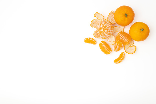 Ripe tangerines sliced and whole isolated on a white background, top view.