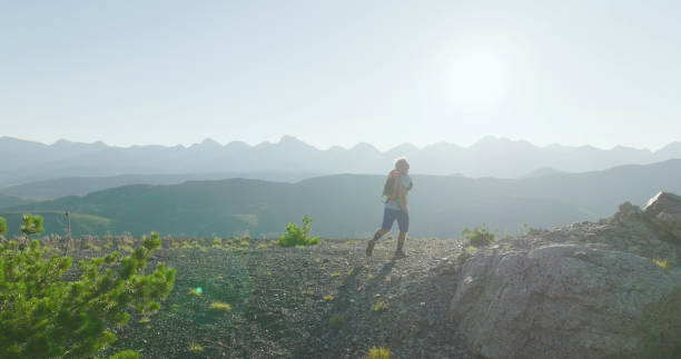 istock Senior male trail runner bounds along mountain ridge 1804141722