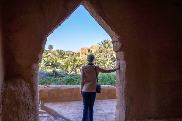 una turista solitaria occidentale in piedi nell'arco, ushaiqer heritage village - women rear view one person arch foto e immagini stock