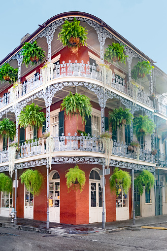 building with iron balcony with green flowers in french quarter of New Orleans, USA