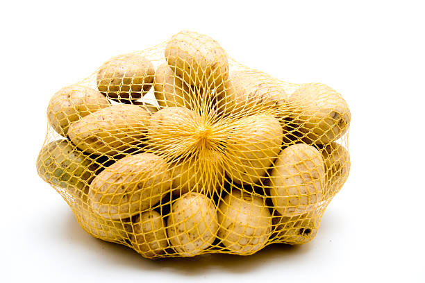 свежег�о картофеля в сеть - raw potato root vegetable vegetable sack стоковые фото и изображения