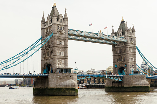 London, UK - September 4, 2019: Low angle picture of the iconic Tower Bridge -inaugurated in 1894- in a sunny day and with a cloudy blue sky as background