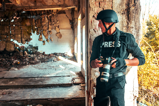 man war journalist with camera on the field