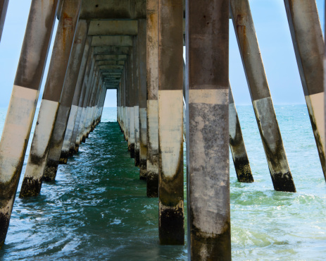 Diminishing perspective on the ocean beneath a fishing pier