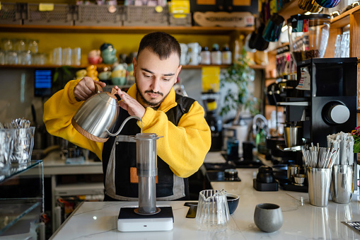 Barista making espresso coffee with Aeropress in barista shop