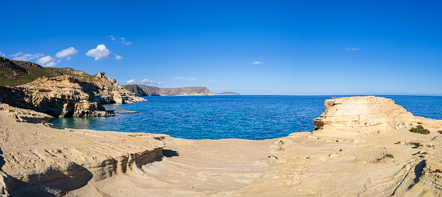 People fishing on a rocky beach of east Attica, Greece on a sunny day.