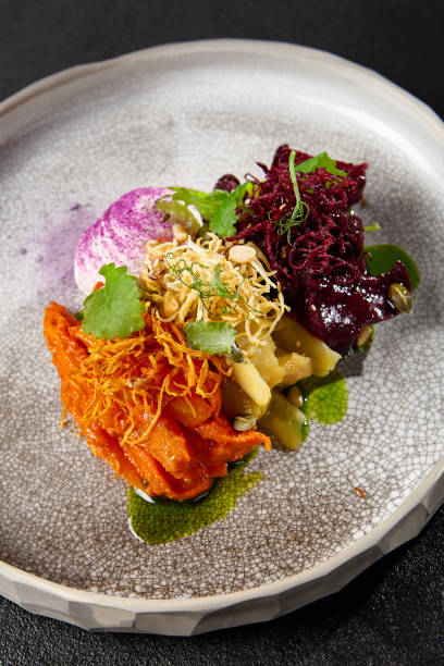 istock Baked root vegetables in handmade ceramic dishware. Vegan food - caramelized carrot, beetroot and celery on modern crockery. Vegetarian food innovative recipes 1804239671