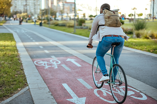 Man rides a bicycle in the city on a bicycle path