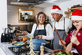 Latin family cooking turkey meat for Christmas dinner at home in Mexico Latin America, hispanic people with teenagers daughter, son, mother and father