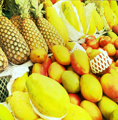 Vintage photo of melons, pineapples, mango at a food market