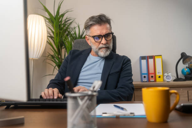 istock Mature businessman typing on keyboard 1804300717