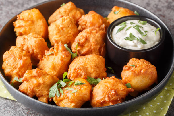 istock Hush puppies is made with eggs, onion, self-rising flour, and cornmeal, then deep-fried until crisp and golden closeup on the plate. Horizontal 1804308435