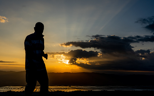 portrait of a man standing while walking at sunset in the open air