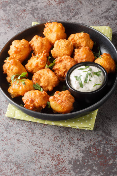 istock Hush puppies, southern food, deep fried cornbread balls closeup on the plate. Vertical 1804310941