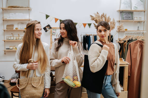 Three girls in an eco-friendly store, each holding a bag.