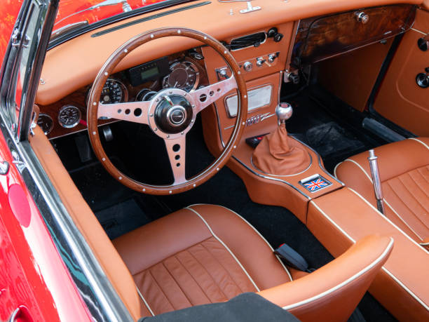 A classic British vintage car wooden steering wheel and dashboard in blue