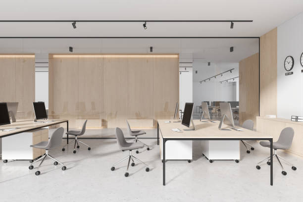 istock Stylish office interior with pc desktop, wooden table and business hall 1804329929