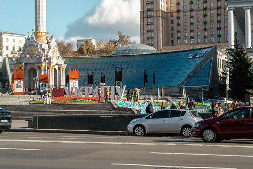 Kyiv, Ukraine - October 17, 2023: cars pass by on the street Maidan Nezalezhnosti. People are walking in the background. The inscription 