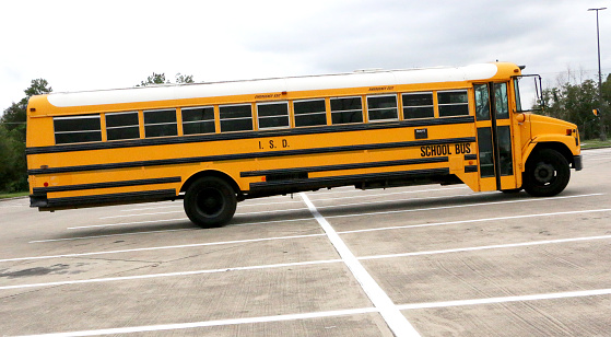 a school bus in the parking lot of a high school sports event