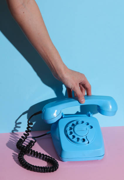 istock HAnd holding Blue Rotary retro rotary telephone handset on pink blue background with shadow. Creative layout 1804340138