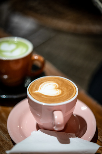 Roasted coffee beans with cappuccino with heartbeat foam design,top view