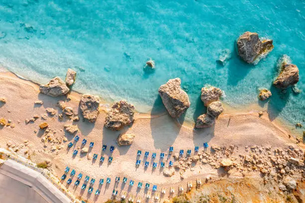 Drone view of lounge chairs by sea in Lefkada, Greece