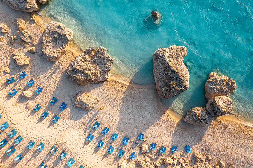 Drone view of lounge chairs by sea in Lefkada, Greece