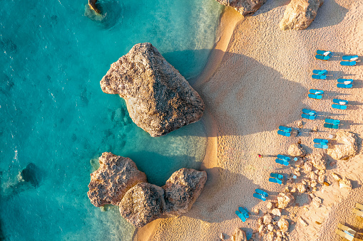 Drone view of lounge chairs by sea in Lefkada, Greece