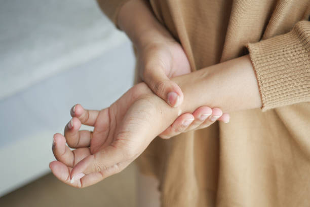 istock Young women hands suffering wrist pain, 1804345634