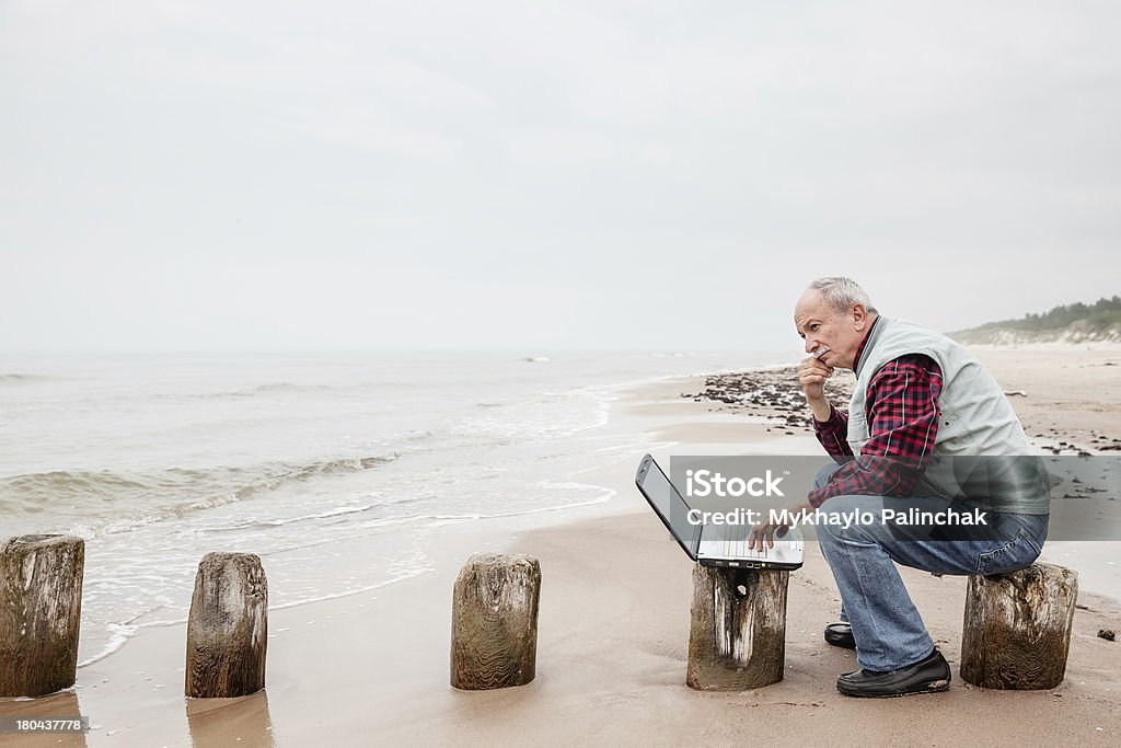 Velho homem com notebook na praia - Royalty-free Adulto Foto de stock