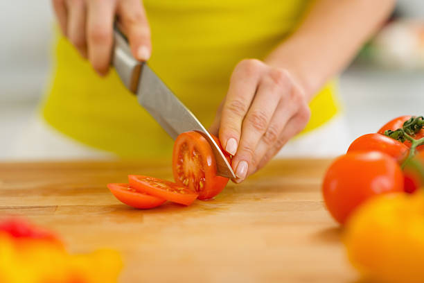 istock Closeup on woman cutting tomato 180440062