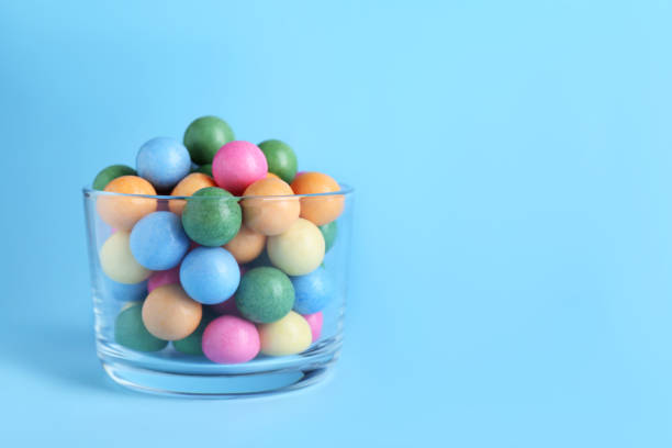 istock Bowl with bright gumballs on light blue background. Space for text 1804401192